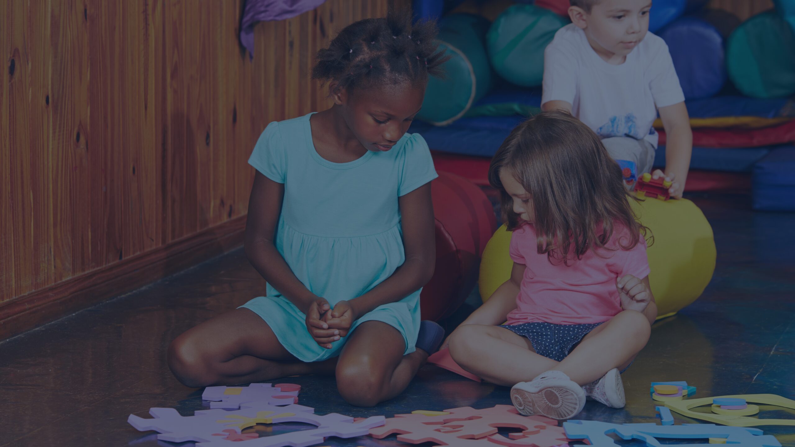 Two young girls playing with blocks during a supervised visitation session, showing child resilience in visitation and positive connection.